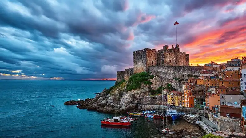 Castillo de piedra, costa, y ocaso