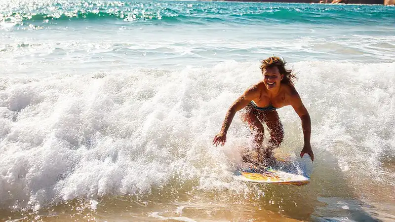 Surfista sonríe en la playa dorada