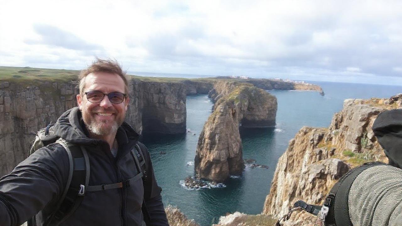 Turista sonríe en costa agreste