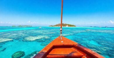 Un barco navega en un paraíso tropical