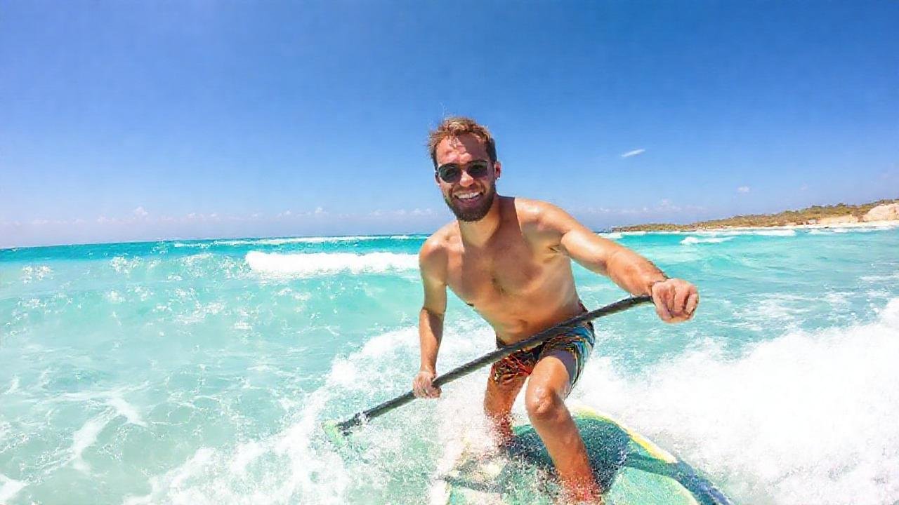 Surfista feliz en playa tropical